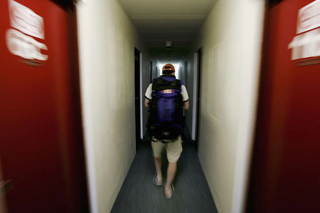 Traveller Craig Weather from Canada walks through a dormitory corridor as he arrives at a backpackers hostel October 14, 2005 in Darwin, Australia. (Ian Waldie/Getty Images)
