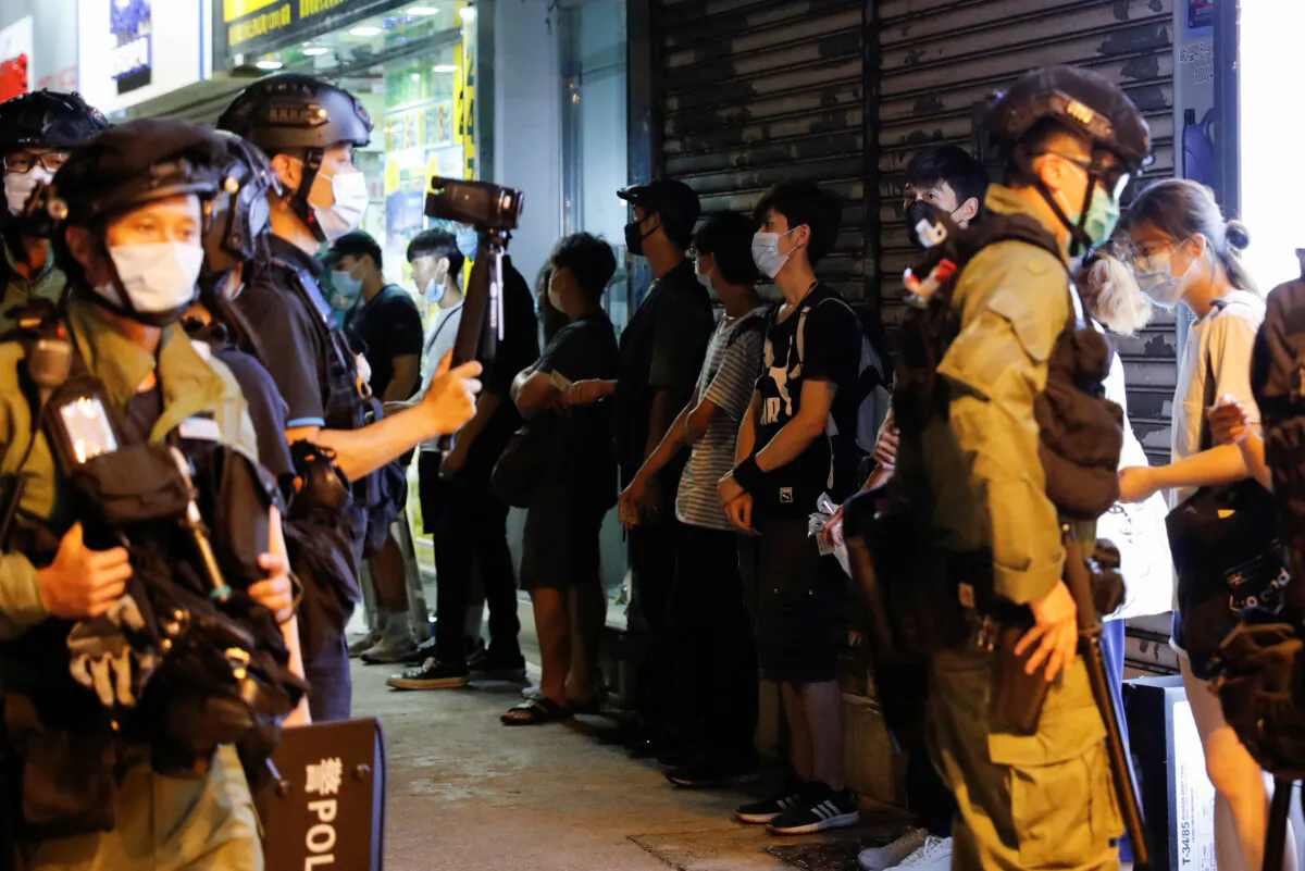 Riot police stop and search people during a protest to mark the first anniversary of an attack in a train station by an armed crowd wearing white shirts, demanding justice for the victims of violence and broader freedoms, at a shopping mall in Hong Kong's Yuen Long, China, on July 21, 2020. (Tyrone Siu/Reuters)