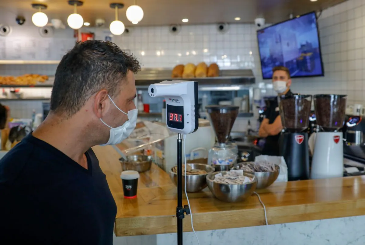 A man checks his body temperature as he enters a coffee shop in Jerusalem, amid a surge in coronavirus cases in Israel, on July 17, 2020. (Ahmad Gharabli / AFP via Getty Images)