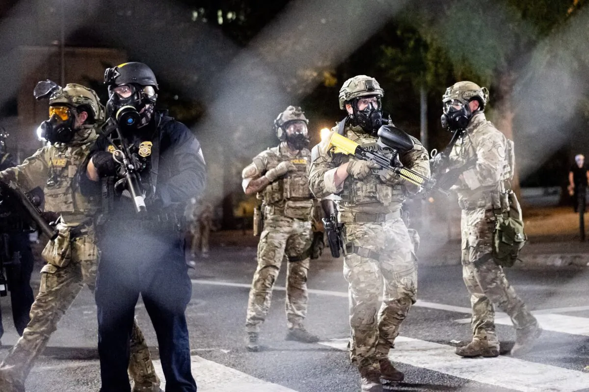 Federal agents disperse demonstrators who used fencing to block entrances and exits to the Mark O. Hatfield United States Courthouse, in Portland, Ore., on July 20, 2020. (Noah Berger/AP Photo)