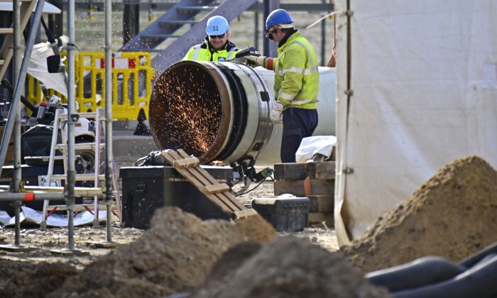 Men work at the construction site of the so-called Nord Stream 2 gas pipeline in Lubmin, northeastern Germany, on March 26, 2019. The Nord Stream 2 pipeline will double the capacity to ship gas from Russia to Germany via the waters of Finland, Sweden, and Denmark. The pipeline has faced opposition from many countries in eastern and central Europe, the United States, and particularly Ukraine because it risks increasing Europe's dependence on Russian natural gas. (Tobias Schwarz/AFP via Getty Images)
