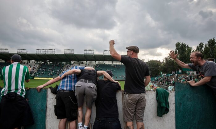 Football fans cheer and stand on ladders as they watch a Czech First League match between Bohemians 1905 and FK Jablonec at Dolicek Stadium in Prague, Czech Republic, on June 14, 2020. (Gabriel Kuchta/Getty Images)