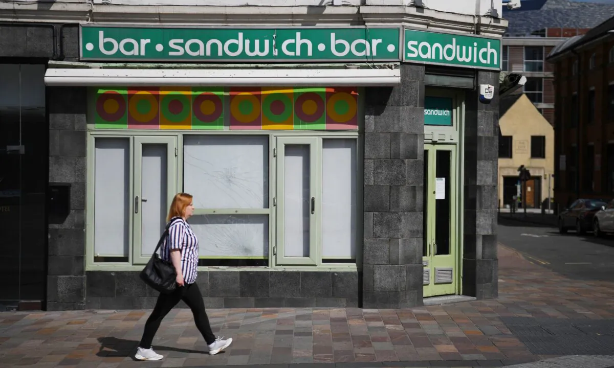A woman walks past a closed shop in Leicester, central England, on July 17, 2020. (Daniel Leal-Olivas/AFP via Getty Images)