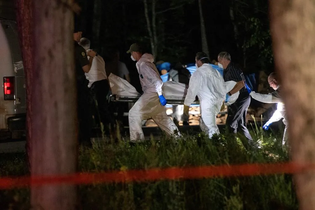 A body believed to be Martin Carpentier is carried by police investigators, Monday, July 20, 2020 in Saint-Apollinaire, Que. (Jacques Boissinot/The Canadian Press)