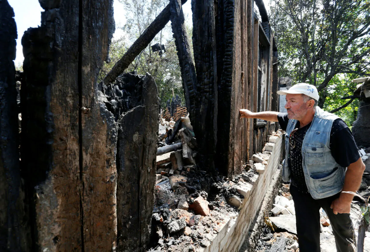 A local resident Ilya, 57, stands next to a house of his relatives, which locals said was destroyed during a recent shelling, in the rebel-controlled city of Donetsk, Ukraine July 22, 2020. (Alexander Ermochenko/Reuters)