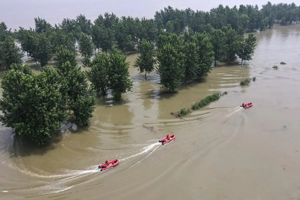 Firefighters are patrolling with boats at a flooded area near the Yangtze River in Zhenjiang, in China's eastern Jiangsu Province on July 20, 2020. (STR/AFP via Getty Images)