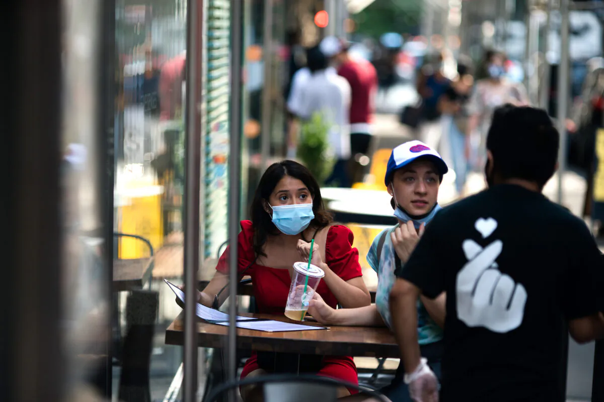 Customers wear protective masks as they order food outside a restaurant in New York City, N.Y., on July 21, 2020. (Jeenah Moon/Getty Images)
