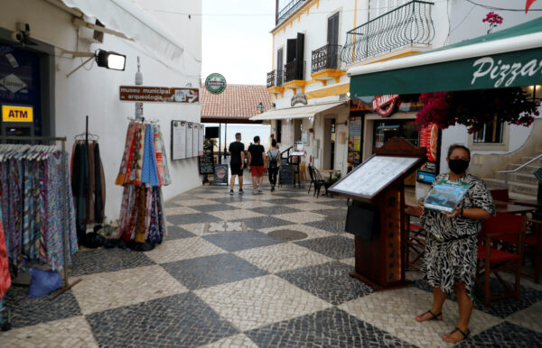 A server offers the menu on a street Albufeira Portugal