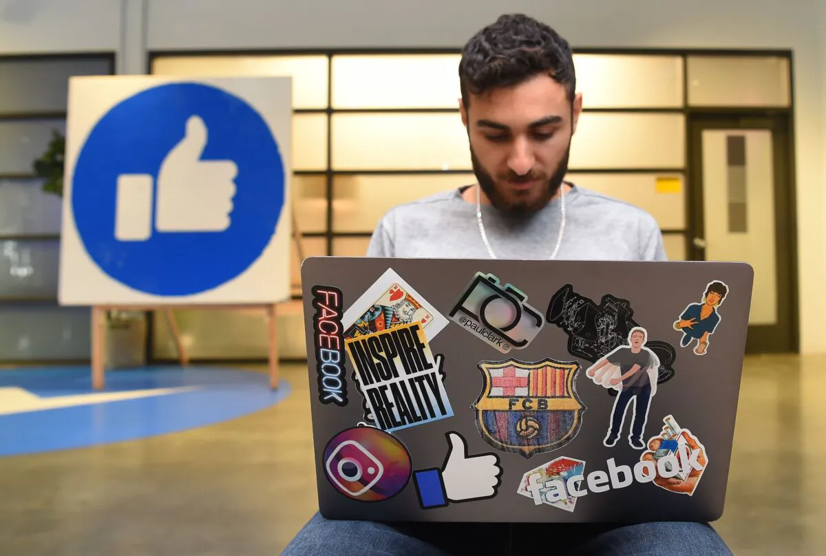 Facebook employee Mohamed Almari works from his laptop decorated in various Facebook stickers at the company's corporate headquarters campus in Menlo Park, Calif., on Oct. 23, 2019. (Josh Edelson/AFP via Getty Images)