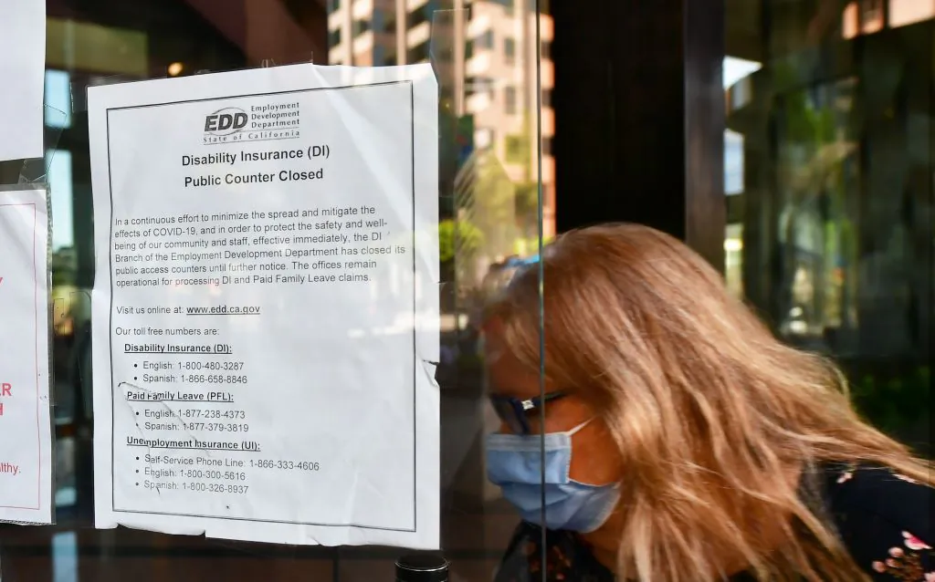 A woman wears a mask as she enters a building where the Employment Development Department (EDD) has its offices in Los Angeles, Calif., on May 4, 2020. (Frederic J. Brown/AFP via Getty Images)