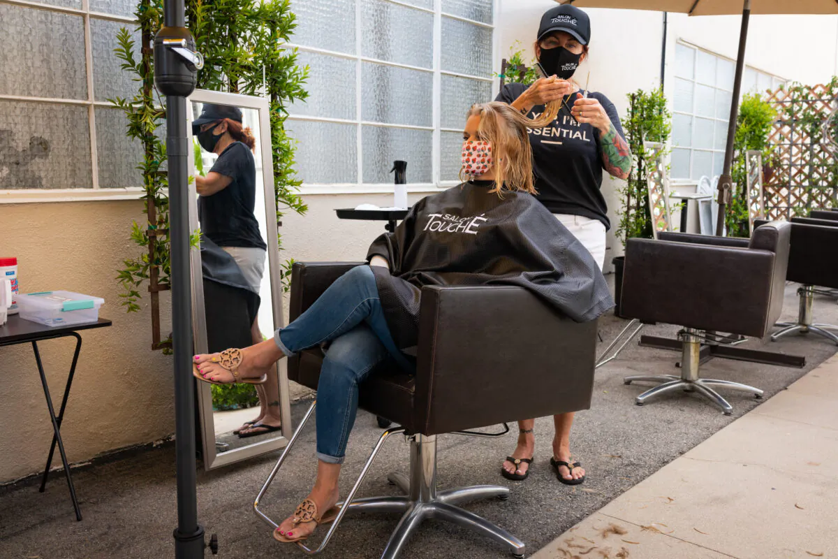 Christina Maniaci cuts a customer's hair at Salon Touché in Redondo Beach, Los Angeles County, on July 22, 2020. (John Fredricks/The Epoch Times)