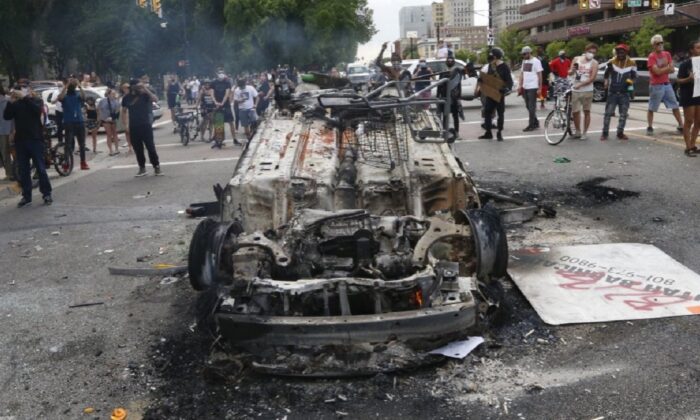 A police vehicle that was overturned and set on fire during riots in Salt Lake City, Utah, is seen on May 30, 2020. (Rick Bowmer/AP Photo)