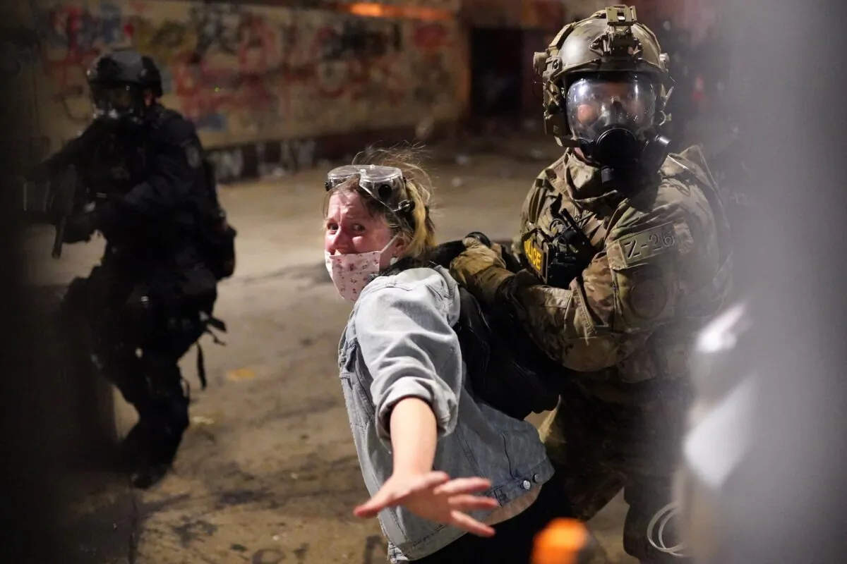 Federal officers arrest a woman after she crossed a fence line set up around the Mark O. Hatfield U.S. Courthouse during a riot in Portland, Ore., on July 23, 2020. (Nathan Howard/Getty Images)