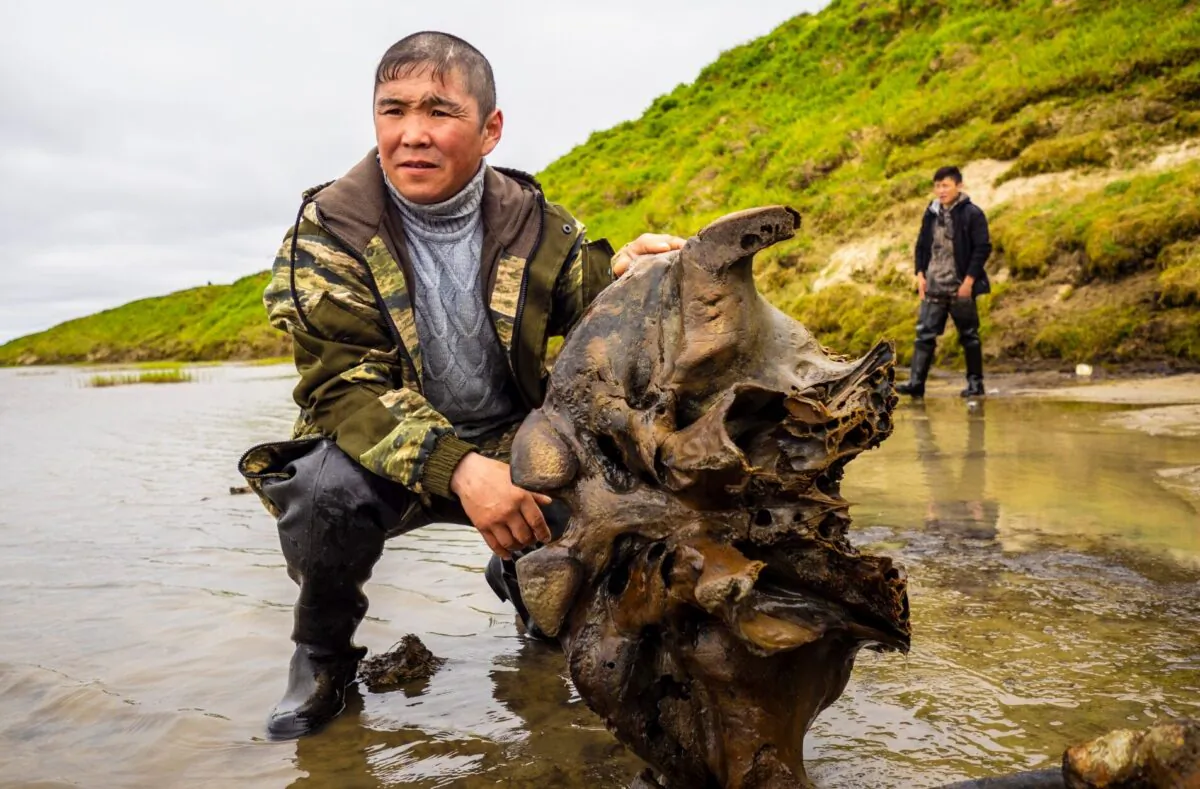 A man holds a mammoth bone fragment in the Pechevalavato Lake in the Yamalo-Nenets region, Russia, on July 22, 2020. (Artem Cheremisov/Governor of Yamalo-Nenets region of Russia Press Office via AP)