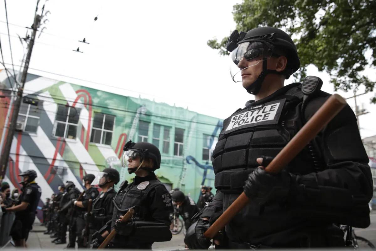 Seattle police officers stand guard outside a precinct as people protest the death of George Floyd, in the Capitol Hill neighborhood of Seattle, Wash. on June 1, 2020. (Jason Redmond/AFP via Getty Images)