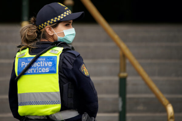 A Protective Services Officer wearing a face mask patrols Flinders Street station in Melbourne