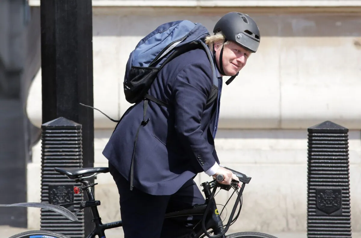 In this file photo, British Prime Minister Boris Johnson rides his bicycle through Westminster in central London on July 6, 2016. (Daniel Leal Olivas/AFP/AFP via Getty Images)