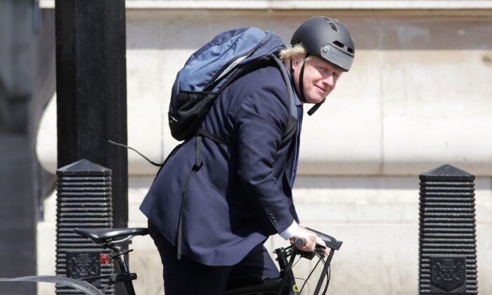 In this file photo, British Prime Minister Boris Johnson rides his bicycle through Westminster in central London on July 6, 2016. (Daniel Leal Olivas/AFP/AFP via Getty Images)