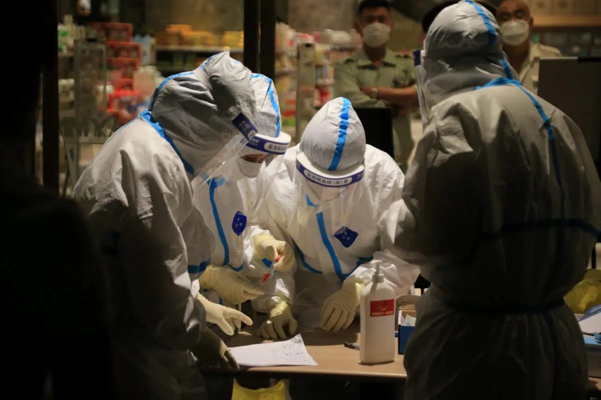 Health workers carrying out COVID-19 tests in a shopping mall in Dalian, in China's northeast Liaoning Province, on July 25, 2020. (STR/AFP via Getty Images)