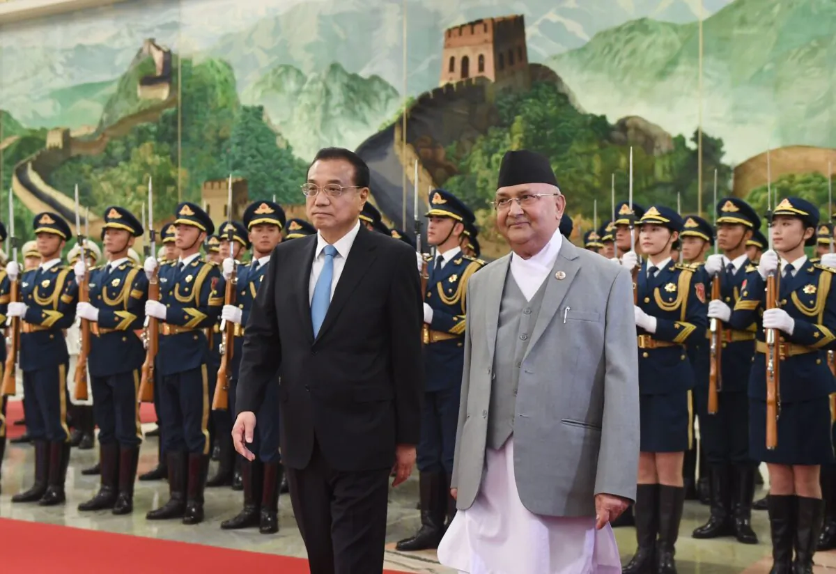Nepal's Prime Minister K.P. Sharma Oli (center R) reviews a military honour guard with Chinese Premier Li Keqiang during a welcome ceremony at the Great Hall of the People in Beijing on June 21, 2018. (GREG BAKER/AFP via Getty Images)
