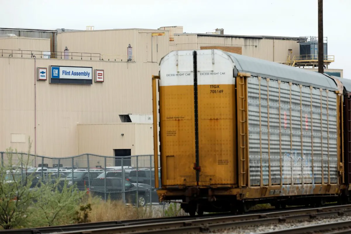Train cars that haul vehicles are viewed outside the General Motors Flint Assembly plant in Flint, Mich., on May 18, 2020. (Jeff Kowalsky / AFP via Getty Images)