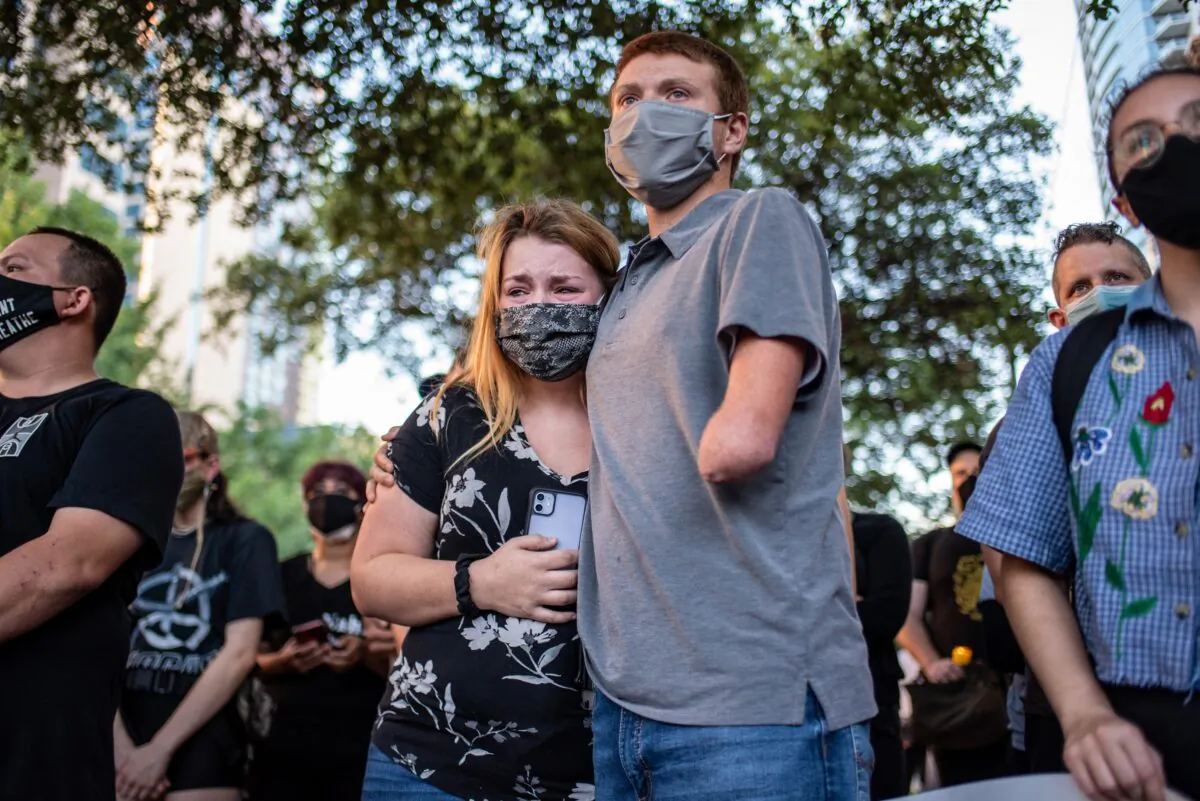 Anna Mayo, Garrett Foster's sister, embraces her husband Chase Mayo at a vigil for her brother in downtown Austin, Texas on July 26, 2020. (Sergio Flores/Getty Images)