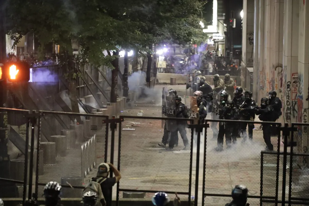 Federal officers walk out in formation to launch tear gas at demonstrators during a riot outside the Mark O. Hatfield Courthouse in Portland, Ore., on July 26, 2020. (Marcio Jose Sanchez/AP Photo)