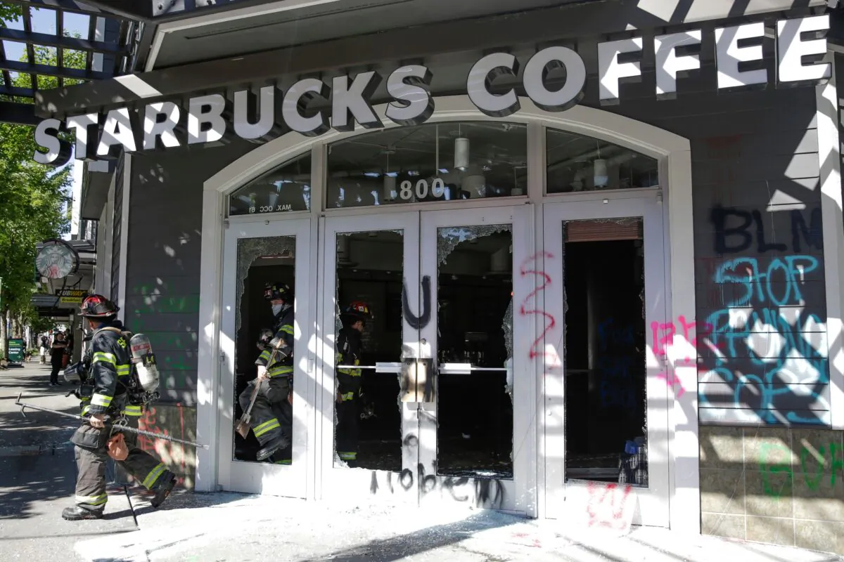 Firefighters exit a Starbucks Coffee that was vandalized by rioters in Seattle, Wash., on July 25, 2020. (Jason Redmond/AFP via Getty Images)
