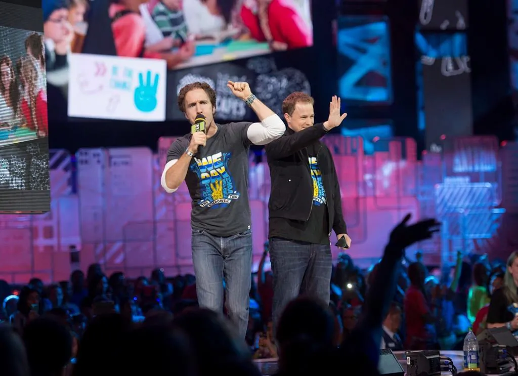 Craig Kielburger and Marc Kielburger speak during "We Day" in Toronto on Oct. 2, 2014. (Hannah Yoon/The Canadian Press)