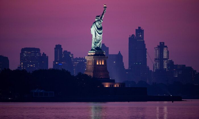 The Statue of Liberty is seen in front of the skyline of Brooklyn before sunrise in New York City on July 9, 2020. (Johannes Eisele/AFP via Getty Images)