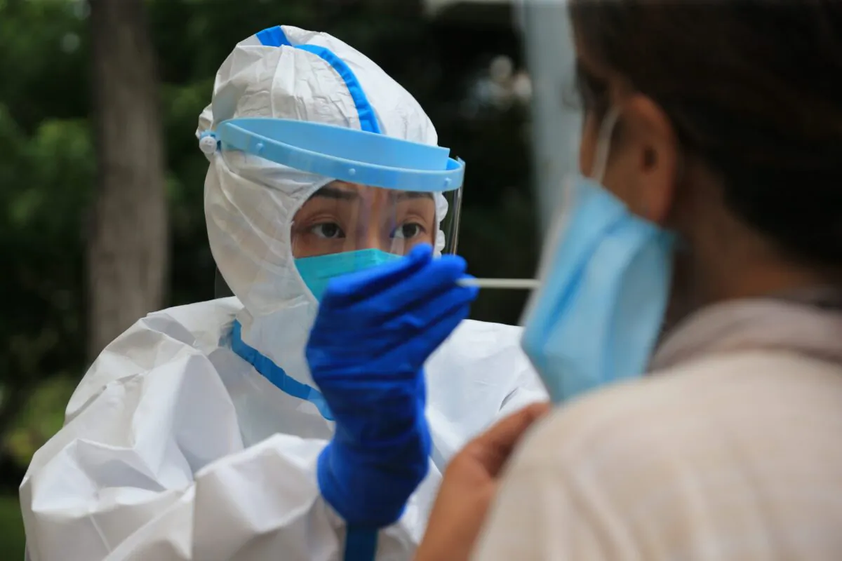 A health worker is carrying out a COVID-19 test in Dalian, in China's northeast Liaoning province on July 26, 2020. (STR/AFP via Getty Images)