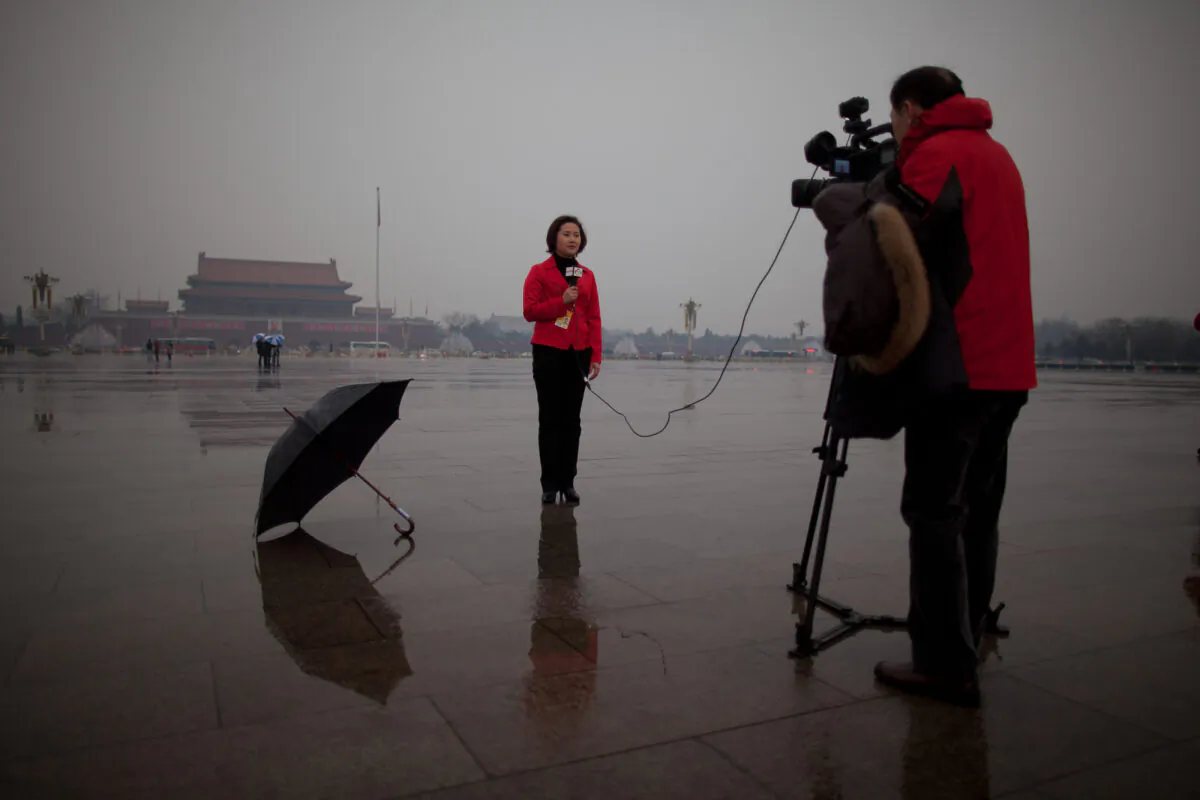 A local television reporter conducts a report from Tiananmen Square, in Beijing on March 12, 2013. (Ed Jones/AFP via Getty Images)