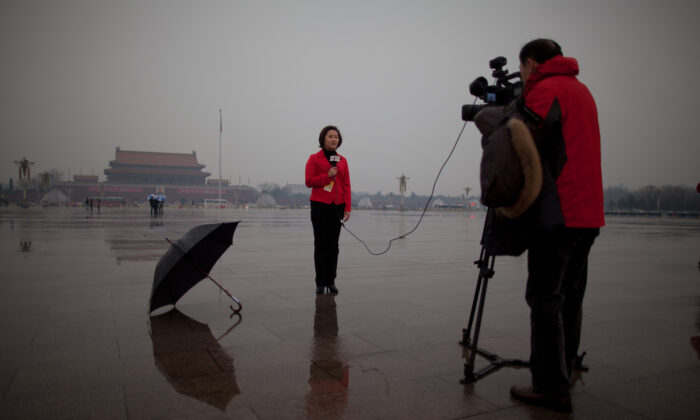 A local television reporter conducts a report from Tiananmen Square, in Beijing on March 12, 2013.  (Ed Jones/AFP via Getty Images)