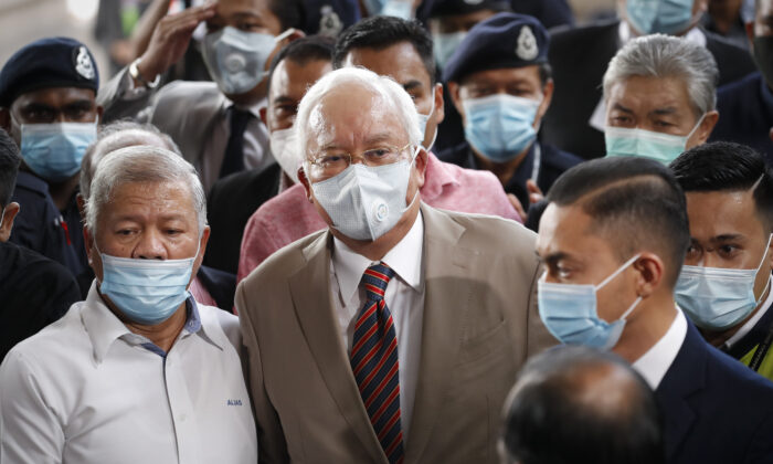 Former Malaysian Prime Minister Najib Razak, center, wearing a face mask with his supporters arrives at courthouse in Kuala Lumpur, Malaysia, on July 28, 2020. (Vincent Thian/AP)