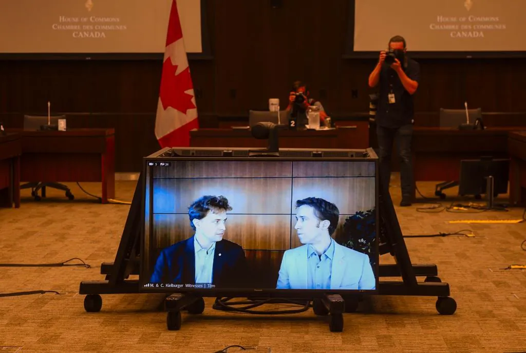 Marc Kielburger, screen left, and Craig Kielburger, screen right, appear as witnesses via videoconference during a House of Commons finance committee in the Wellington Building in Ottawa on July 28, 2020. The committee is looking into Government Spending, WE Charity and the Canada Student Service Grant. (Sean Kilpatrick/The Canadian Press)
