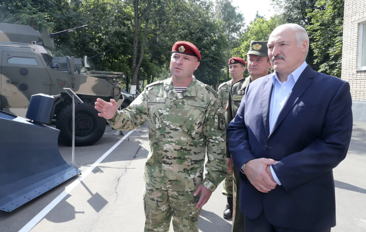 Belarus President Alexander Lukashenko, right, inspects police vehicles as he visits the Belarusian Interior Ministry special forces base in Minsk, Belarus, Tuesday, July 28, 2020. The presidential election in Belarus is scheduled for Aug. 9, 2020. (Nikolai Petrov/AP Photo)