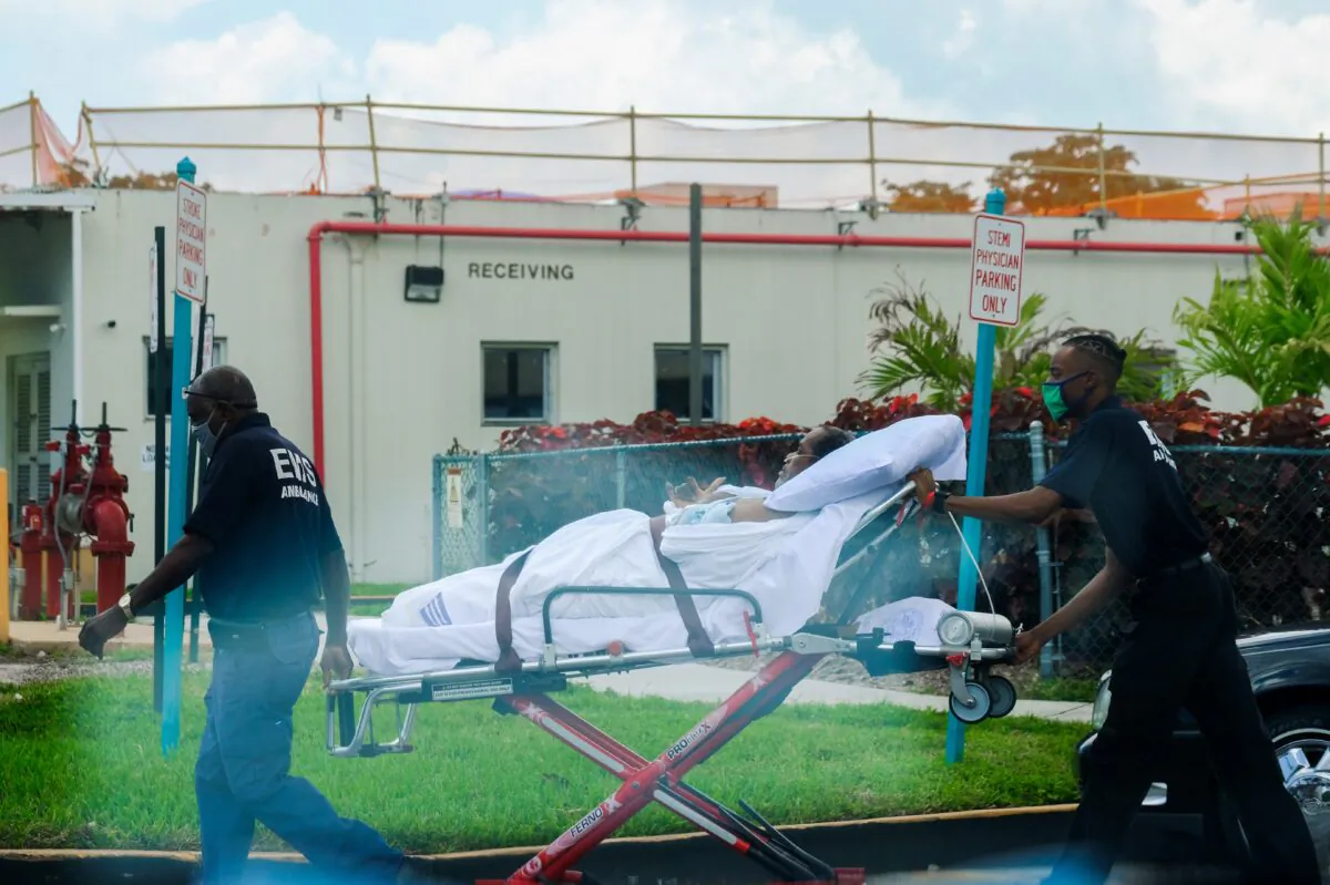 Emergency medical technicians leave with a patient at North Shore Medical Center, where COVID-19 patients are treated, in Miami, Fla., on July 14, 2020. (Maria Alejandra Cardona/Reuters)