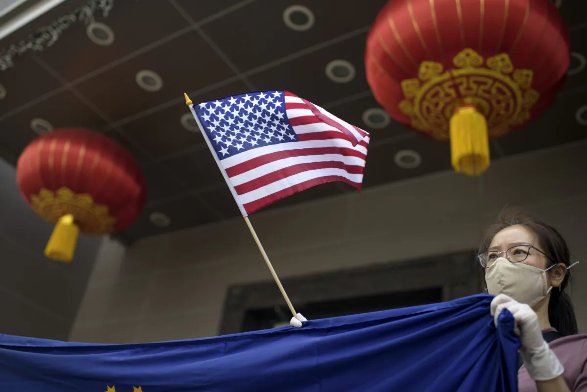 A protester holds a U.S. flag outside of the Chinese consulate in Houston on July 24, 2020. (Mark Felix/AFP via Getty Images)
