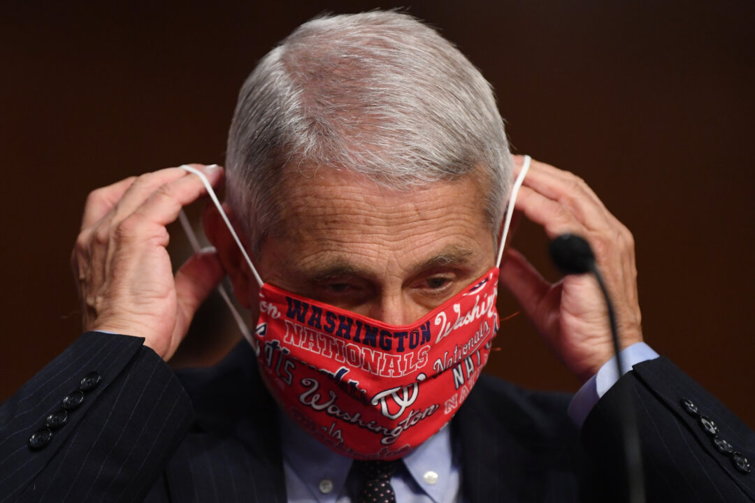 Dr. Anthony Fauci, director of the National Institute for Allergy and Infectious Diseases, lowers his face mask before testifying at a Senate committee in Washington on June 30, 2020. (Kevin Dietsch/Pool/Getty Images)