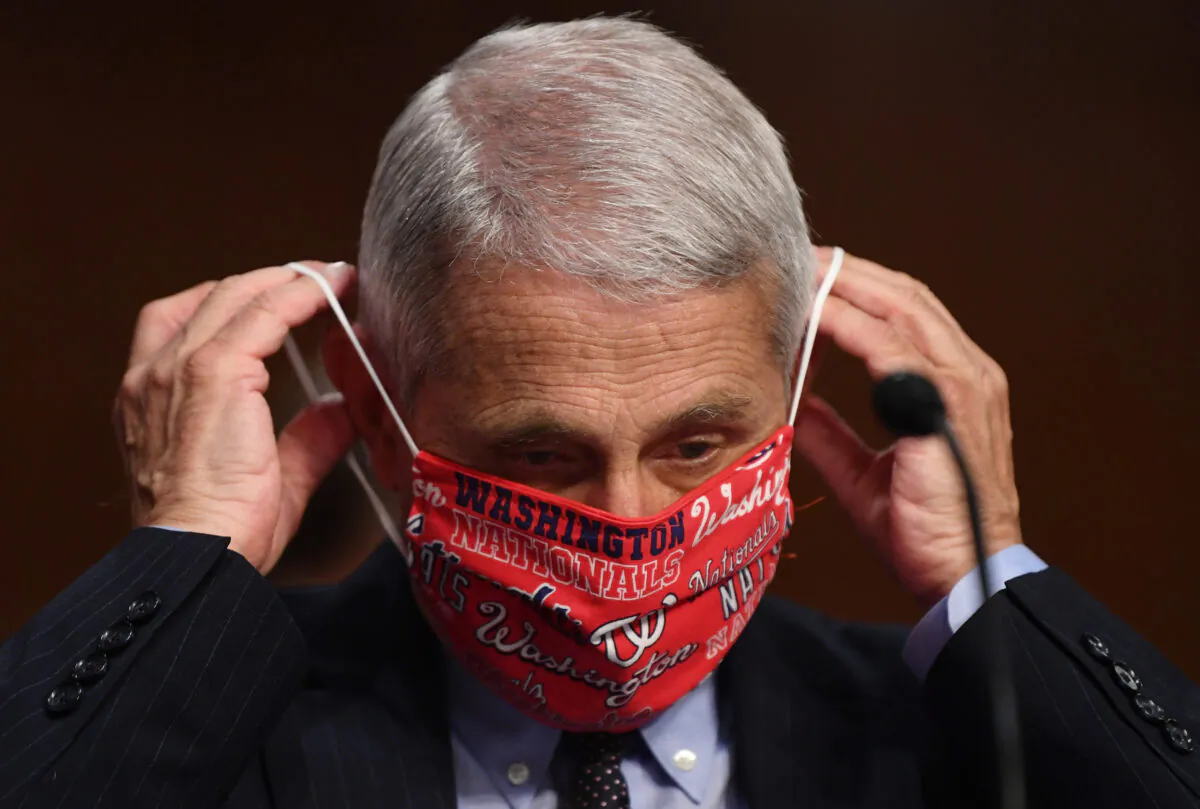 Dr. Anthony Fauci, director of the National Institute for Allergy and Infectious Diseases, lowers his face mask before testifying at a Senate committee in Washington on June 30, 2020. (Kevin Dietsch/Pool/Getty Images)