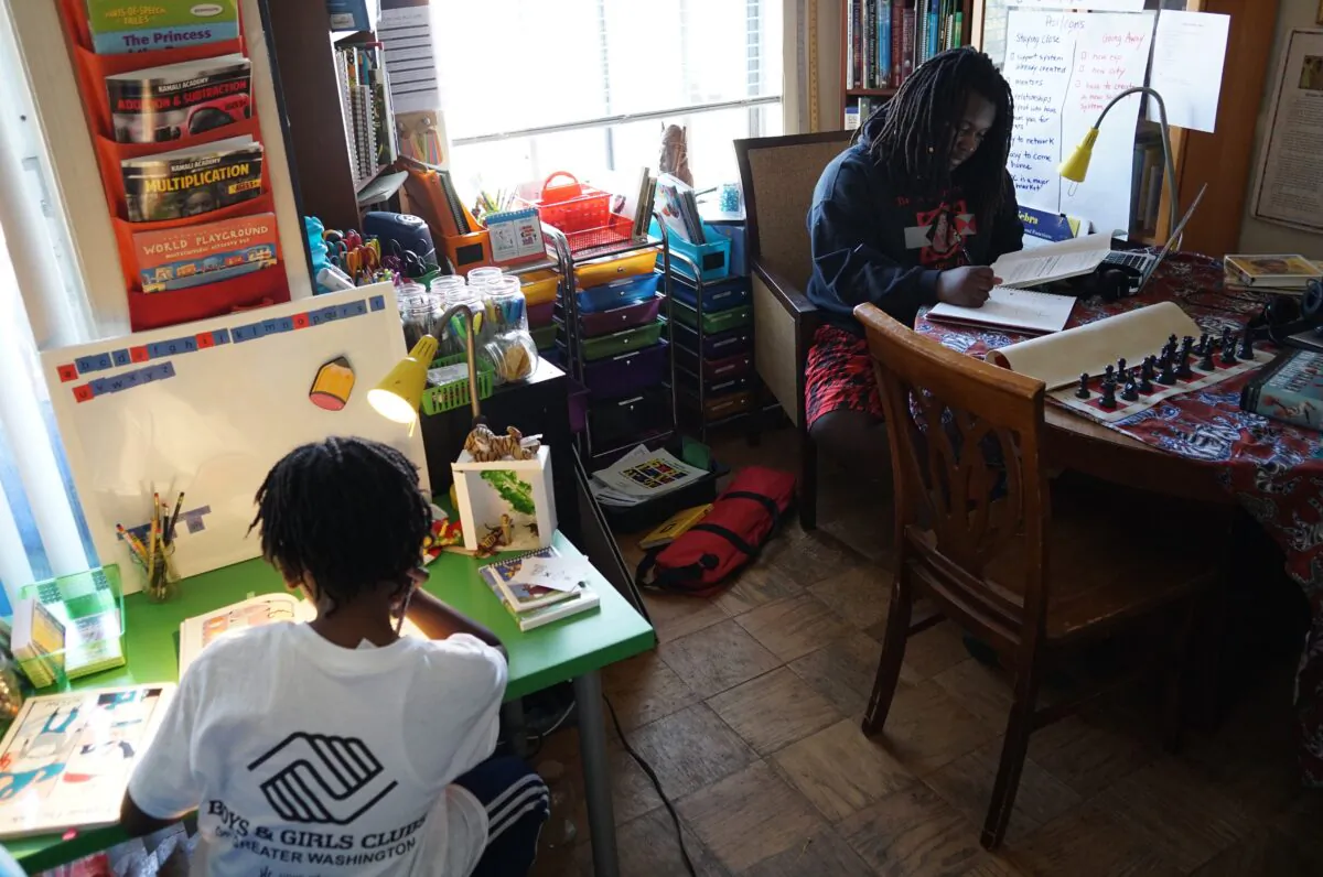 Ayinde (L), age 10, and Zion, 17, do their school work at their home in Washington, on Feb. 24, 2017. (Mandel Ngan/AFP via Getty Images)