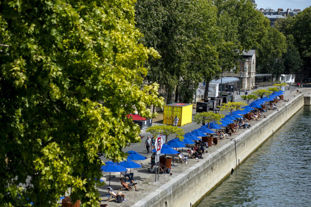 People sit along the river Seine in Paris July 28, 2020. (Kamil Zihnioglu/AP Photo)