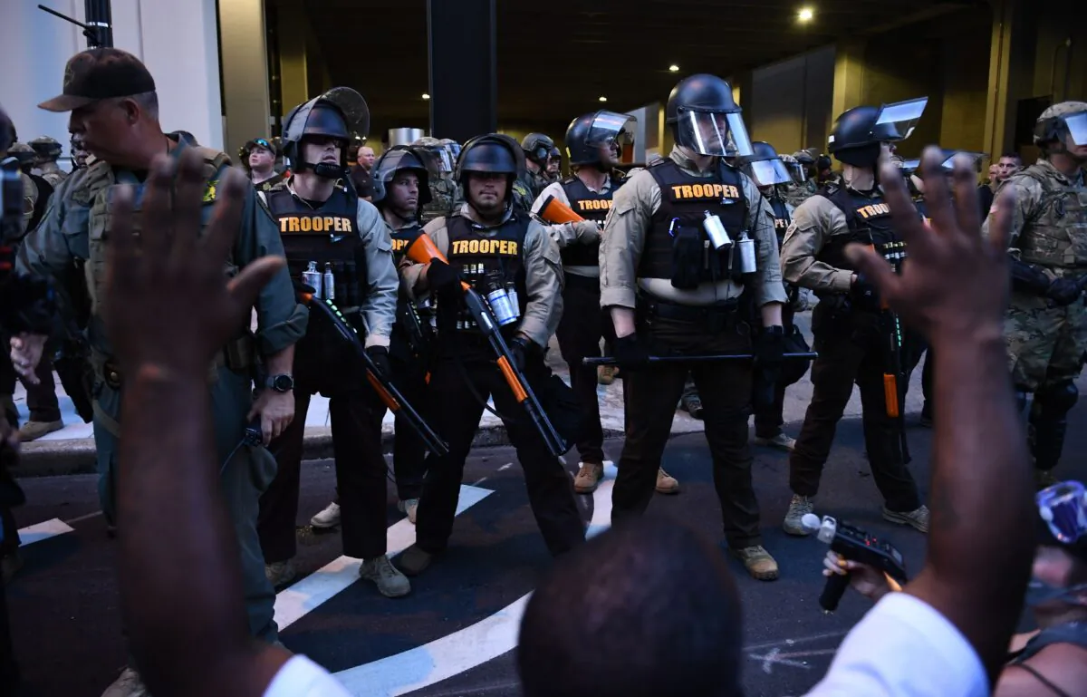 Supporters of "Black Lives Matter" hold their hands up in front of a line of State troopers and National Guards in Tulsa, Oklahoma where Donald Trump held a campaign rally at the BOK Center on June 20, 2020. (Brendan Smialowski/AFP via Getty Images)