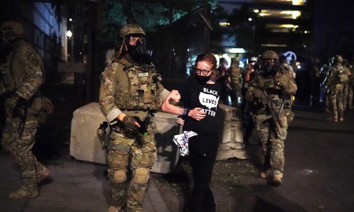 Federal officers arrest a woman wearing a "Black Lives Matter" shirt outside the Mark O. Hatfield Courthouse in Portland, Ore., in the early hours of July 30, 2020. (Nathan Howard/Getty Images)