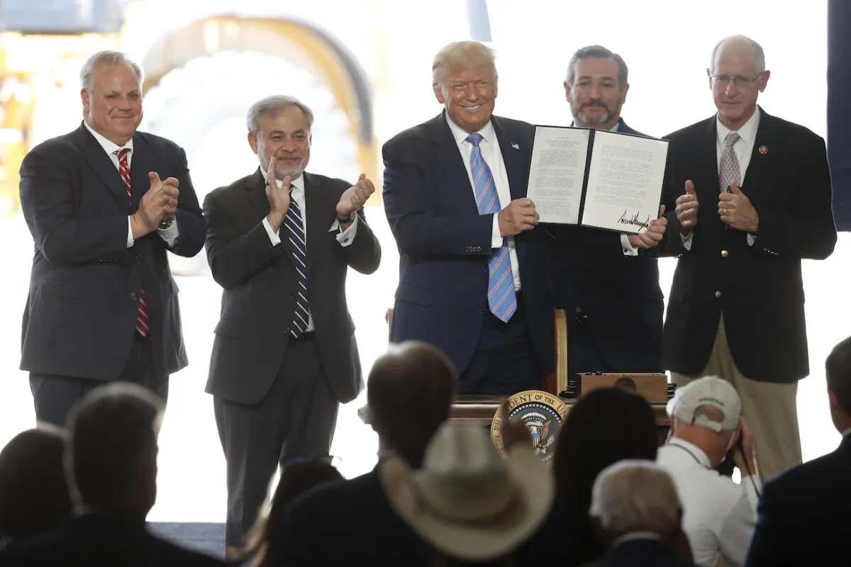 President Donald Trump holds up a permit for energy development after signing it during a visit to the Double Eagle Development oil rig, in Midland, Texas, on July 29, 2020. (Tony Gutierrez/AP Photo)