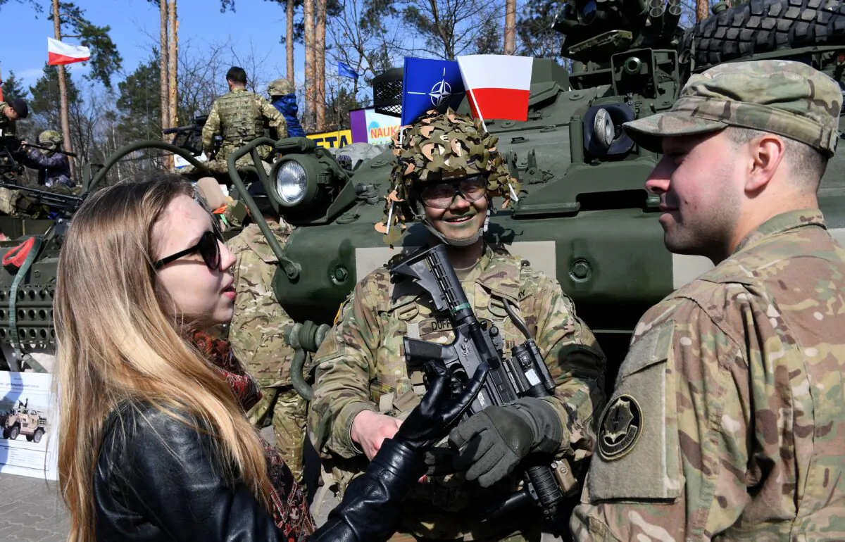 U.S. soldiers speak with a woman in the Wesola district of Polands capital Warsaw on March 29, 2017. (Janek Skarzynski/AFP via Getty Images)