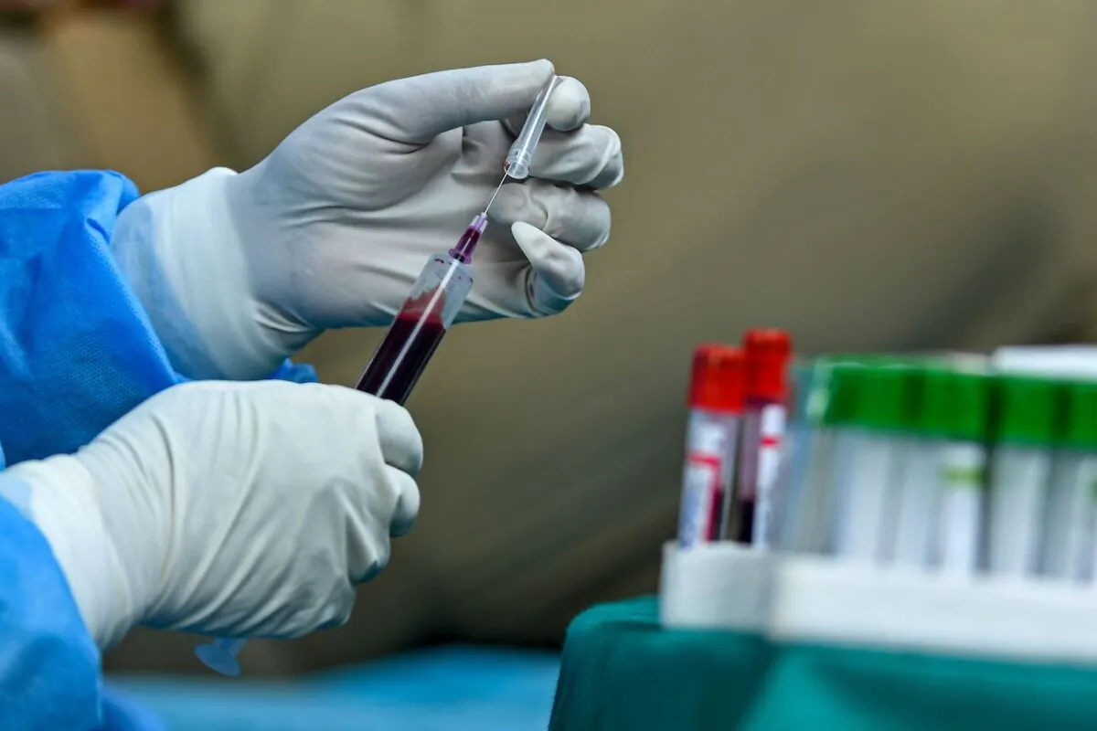 A health worker holds a blood sample donated by a recovered COVID-19 coronavirus patient for plasma at a donation camp in Srinagar, India, on July 22, 2020. (Tauseef Mustafa/AFP via Getty Images)