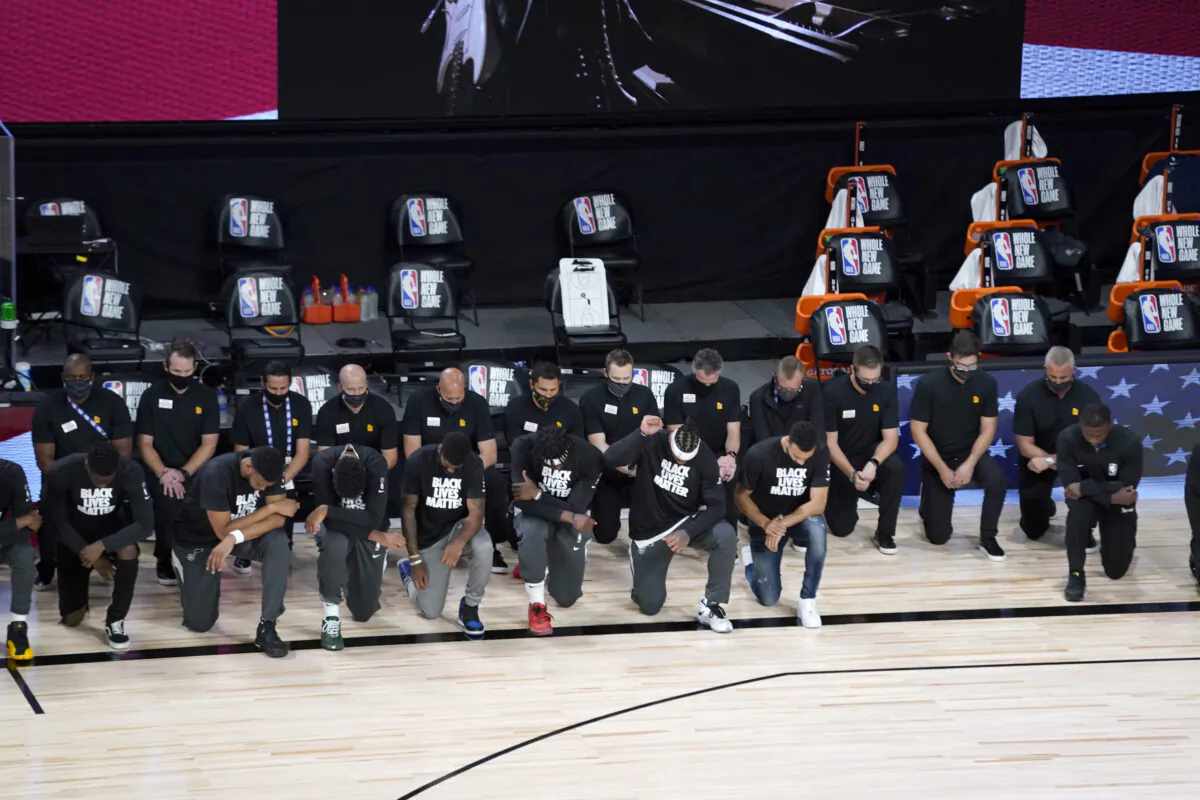 Players and other personnel kneel during the national anthem before the start of an NBA basketball game between the New Orleans Pelicans and the Utah Jazz in Lake Buena Vista, Fla., on  July 30, 2020. (Ashley Landis/Pool/AP Photo)