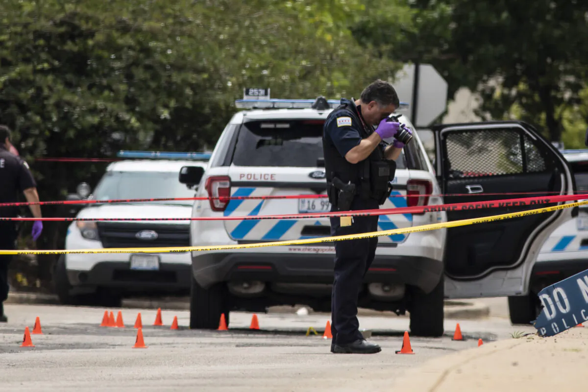 Chicago Police investigate at the 25th District station on the northwest side, in Chicago, after several officers were shot outside the station, Chicago, on July 30, 2020. (Ashlee Rezin Garcia/Chicago Sun-Times via AP)