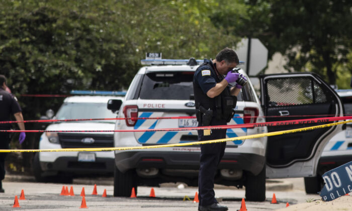 Chicago Police investigate at the 25th District station on the northwest side, in Chicago, after several officers were shot outside the station, Chicago, on July 30, 2020. (Ashlee Rezin Garcia/Chicago Sun-Times via AP)